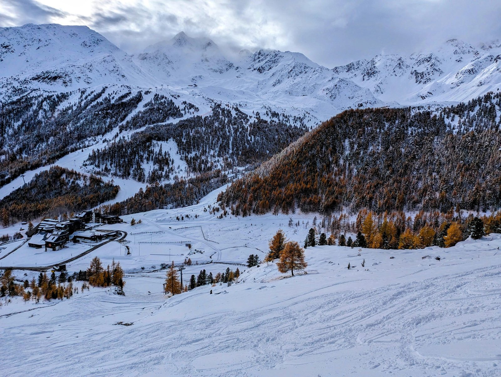 a snow covered mountain with a ski resort in the distance