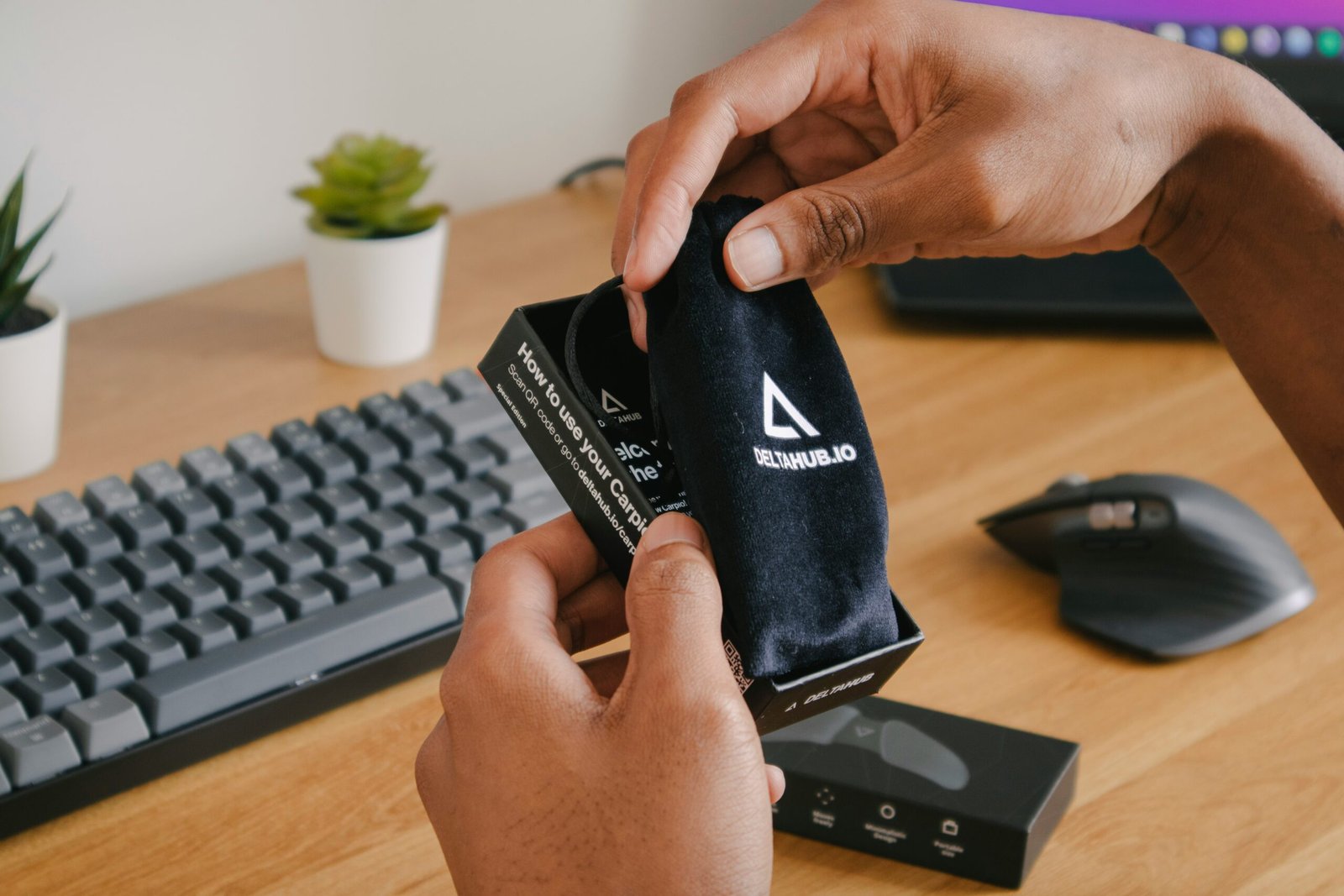 person holding black and white adidas pouch