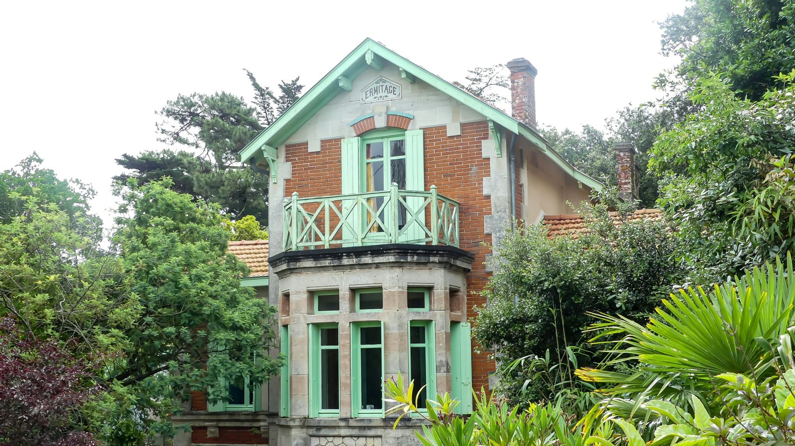 A house with a green roof surrounded by trees